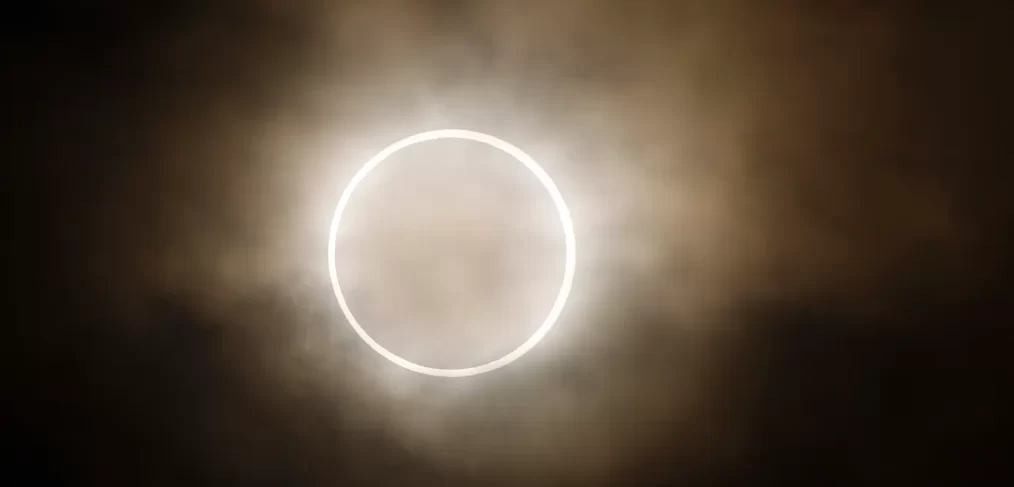 Annular Eclipse against black sky and clouds