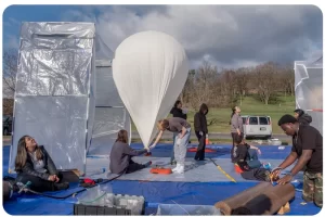 Student volunteers prepare a balloon for a morning launch in Cumberland, Md. On April 8, eclipse day, hundreds of balloons will be launched into the path of the eclipse to study the atmosphere.