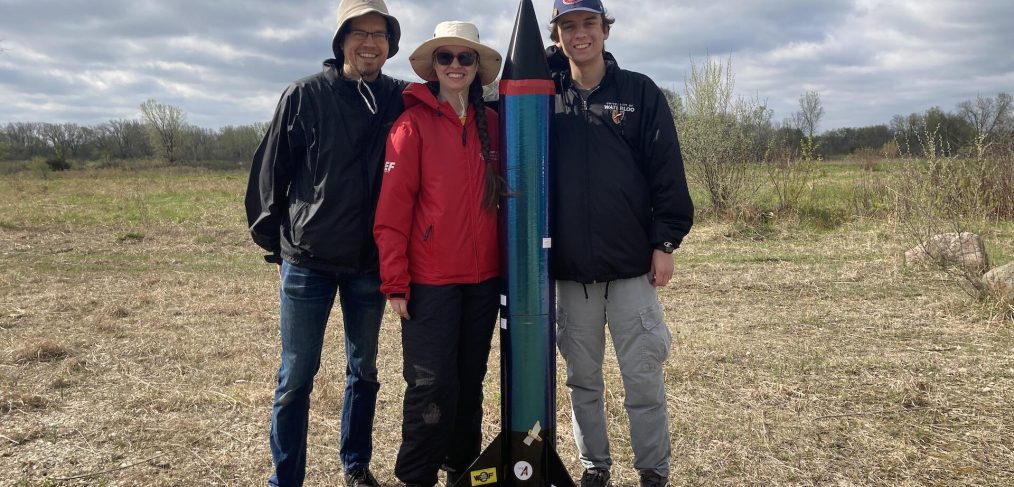 University of Waterloo Team Poses outdoors next to rocket