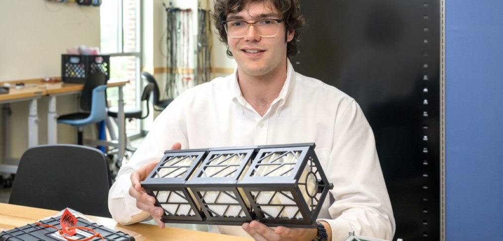 UD junior Timothy “TJ” Tomaszewski is the leader of a UD student team working with NASA to build and launch Delaware’s first orbital spacecraft. He holds a model of a CubeSat, a small modular satellite, which the students will create to study how the sun affects the Earth’s upper atmosphere.