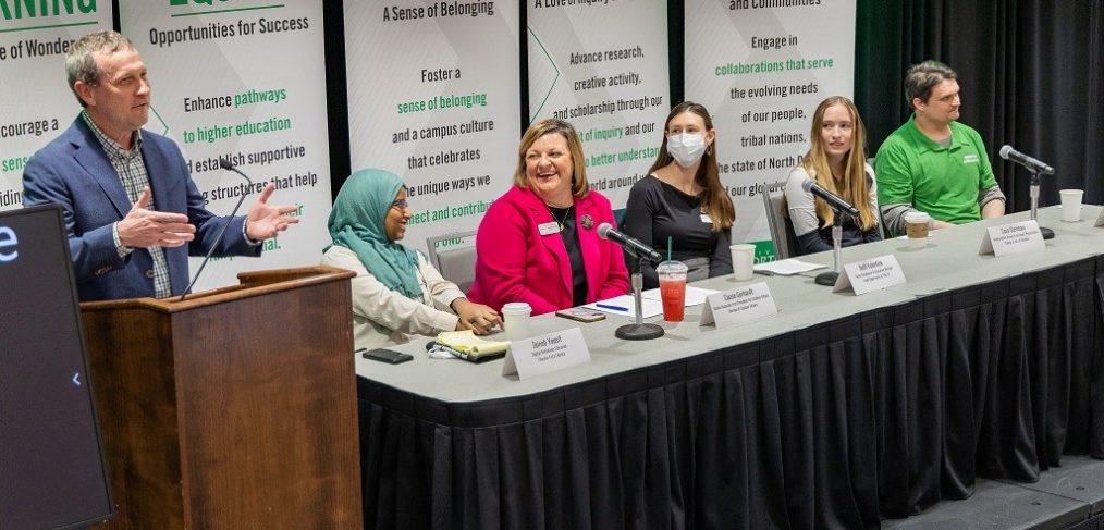 (Panelists at table, from left) Zeineb Yousif, digital initiatives librarian at the Chester Fritz Library; Cassie Gerhardt, senior associate vice president for Student Affairs; Beth Valentine, equity, compliance and education manager, Office of Equal Opportunity and Title IX; Casia Steinhaus, physics major and undergraduate research assistant; and Nathaniel Johnson, assistant professor of Nutrition and Dietetics, respond to moderator Ryan Zerr, associate vice president for Strategy & Implementation, at the ‘Celebrate UND LEADS: An update on the Strategic Plan’ event in the Memorial Union on Feb. 25. Photo by Tom Dennis/UND Today.