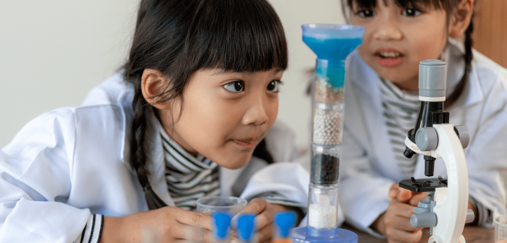 Two young girls conduct science experiment