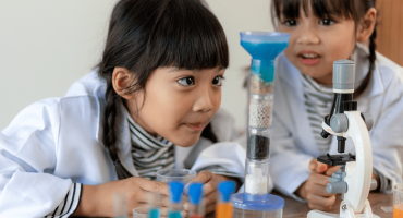 Two young girls conduct science experiment