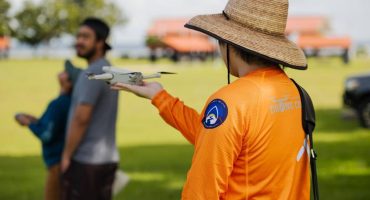 Student researcher holding drone in the field