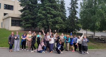 Educators attending 2025 IDEAS workshop pose in a group photo outside on the UAF campus