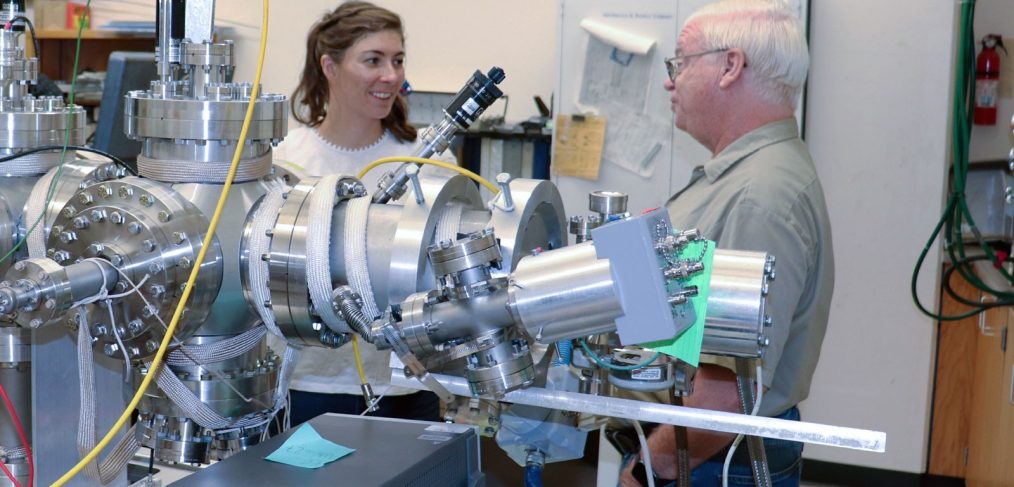 USU Physics doctoral scholar and Utah NASA Space Grant Consortium Fellow Jenny Whiteley, left, examines radiation-induced conductivity instrumentation with Physics Professor J.R. Dennison in his Materials Physics Group. (Photo Credit: USU/M. Muffoletto)