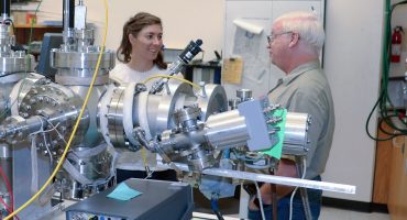 USU Physics doctoral scholar and Utah NASA Space Grant Consortium Fellow Jenny Whiteley, left, examines radiation-induced conductivity instrumentation with Physics Professor J.R. Dennison in his Materials Physics Group. (Photo Credit: USU/M. Muffoletto)