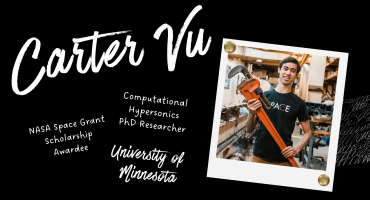 Carter Vu smiling, holding large tool in research lab