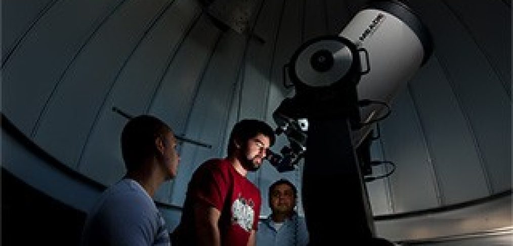 Student looking through telescope at Seton Hall University Astronomical Observatory