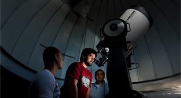 Student looking through telescope at Seton Hall University Astronomical Observatory
