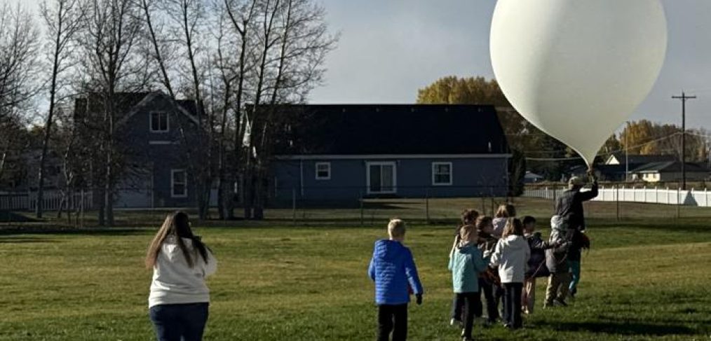 students standing outside with weather balloon