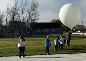students standing outside with weather balloon