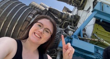 Hannah Jones pointing to rocket engines at NASA Stennis