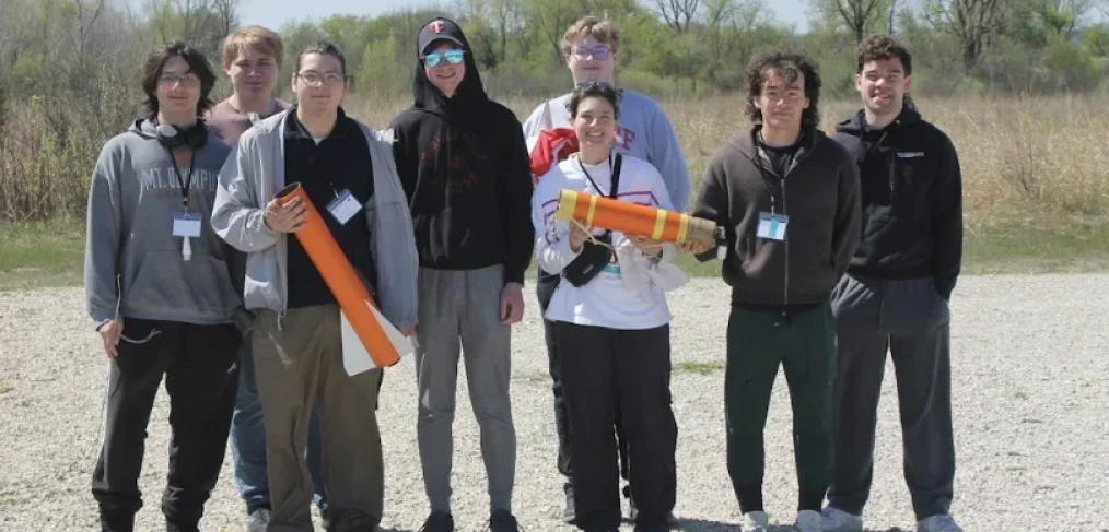 The UW-River Falls Falcon Rocketeers pose for a photo with their winning rocket at the 2026 NASA Wisconsin Space Grant Consortium Collegiate Rocket Launch Competition, held April 24-25 at Richard Bong State Recreational Area in Kansasville. Pictured L-R: Raidyn Bilotta, Sam Sackett, Jonathan Tabora, Peter Bendel, Evan Sander (back), Brook Mclaird (front), Mauricio Cuevas, Ian Vanveen.
