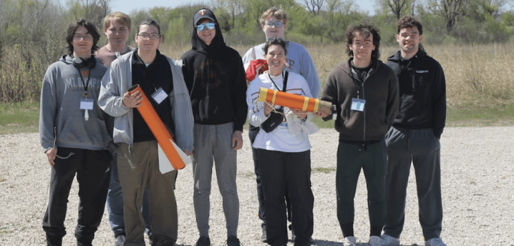 The UW-River Falls Falcon Rocketeers pose for a photo with their winning rocket at the 2026 NASA Wisconsin Space Grant Consortium Collegiate Rocket Launch Competition, held April 24-25 at Richard Bong State Recreational Area in Kansasville. Pictured L-R: Raidyn Bilotta, Sam Sackett, Jonathan Tabora, Peter Bendel, Evan Sander (back), Brook Mclaird (front), Mauricio Cuevas, Ian Vanveen. Contributed photo.